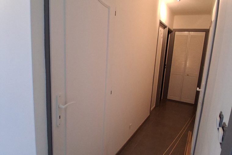 Photographie d'une porte intérieur moulurée dans un couloir à Chauconin Avant sa remise en peinture