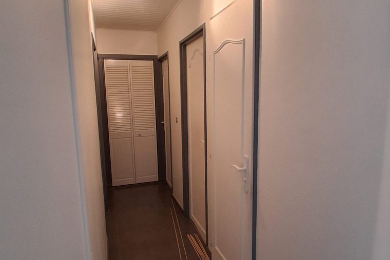 Photographie d'une porte intérieur moulurée dans un couloir à Chauconin Avant sa remise en peinture