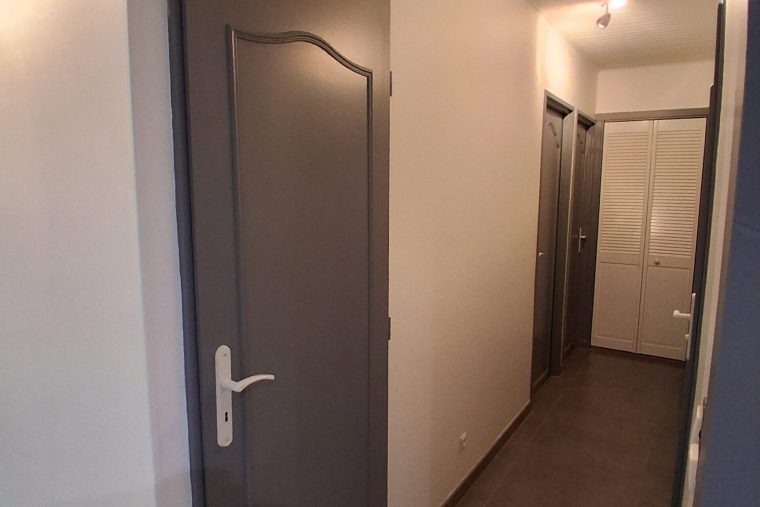 Photographie du résultat après la rénovation en Peinture d'une porte intérieur dans un couloir à Chauconin-Neufmontiers (77)